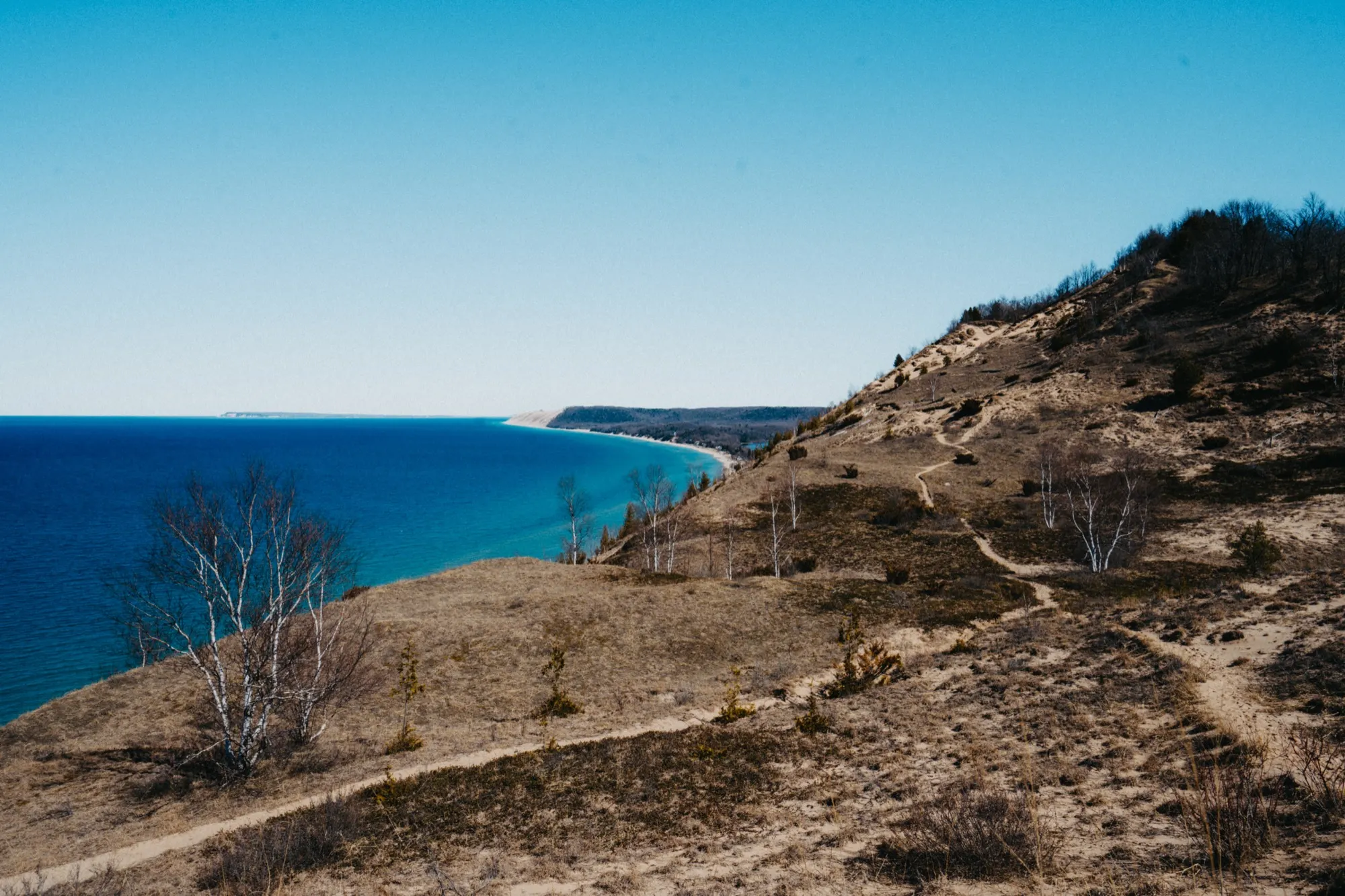 View from high dune overlook showing turquoise Lake Michigan waters and sandy bluffs